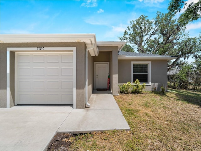 17190/17192 Nixon Ave, Port Charlotte, FL 33948 - view of front of house with an attached garage, stucco siding, concrete driveway, and a front yard