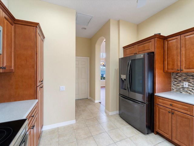 857 Macaw Cir, Venice, FL 34285 - kitchen featuring brown cabinetry, visible vents, backsplash, arched walkways, and stainless steel fridge with ice dispenser