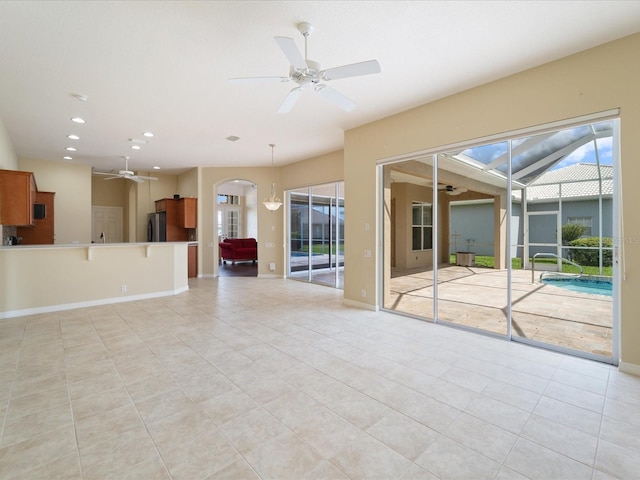 857 Macaw Cir, Venice, FL 34285 - unfurnished living room featuring recessed lighting, light tile patterned flooring, ceiling fan, and arched walkways