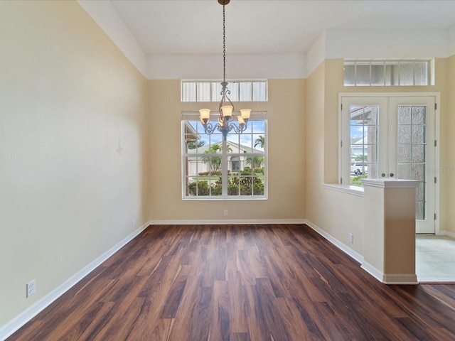 857 Macaw Cir, Venice, FL 34285 - unfurnished dining area with an inviting chandelier, wood finished floors, and baseboards