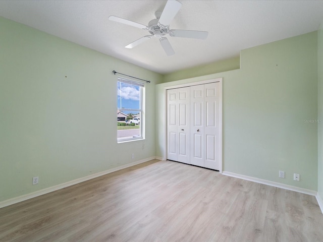 857 Macaw Cir, Venice, FL 34285 - unfurnished bedroom featuring ceiling fan, light wood-style flooring, a closet, and baseboards