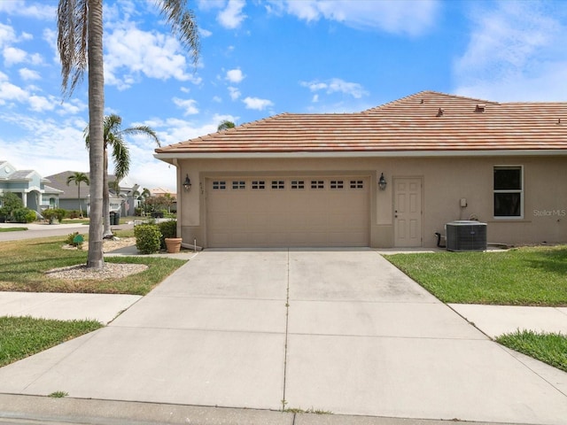 857 Macaw Cir, Venice, FL 34285 - view of front facade featuring an attached garage, central AC, stucco siding, concrete driveway, and a front lawn
