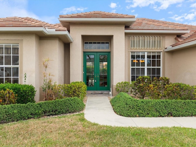 857 Macaw Cir, Venice, FL 34285 - doorway to property featuring stucco siding, a tiled roof, and french doors