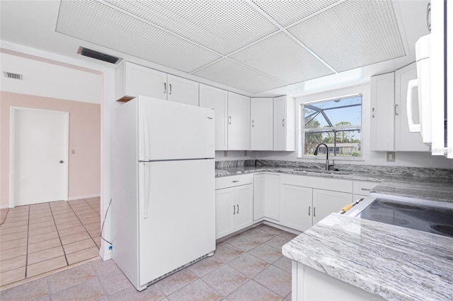 261 Caddy Rd, Rotonda West, FL 33947 - kitchen with white appliances, white cabinets, and light stone counters