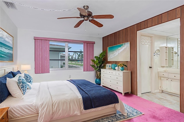 261 Caddy Rd, Rotonda West, FL 33947 - bedroom with wood walls, ensuite bathroom, and ceiling fan