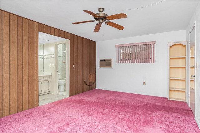 261 Caddy Rd, Rotonda West, FL 33947 - empty room featuring a ceiling fan, wood walls, carpet flooring, and a wall unit AC