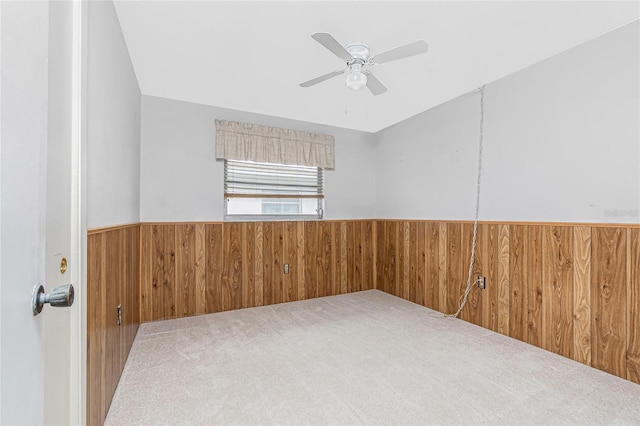 261 Caddy Rd, Rotonda West, FL 33947 - spare room featuring a wainscoted wall, wood walls, ceiling fan, and carpet flooring