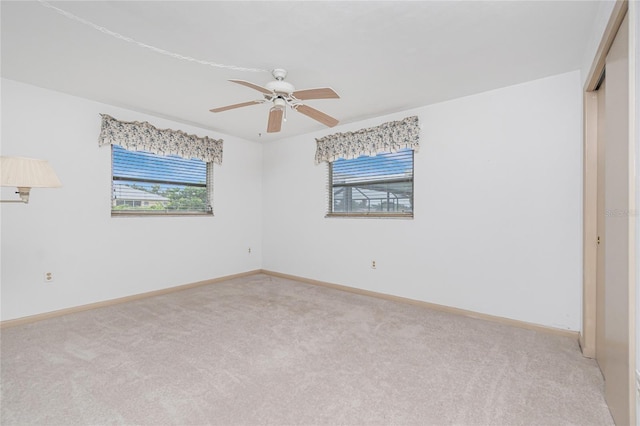 261 Caddy Rd, Rotonda West, FL 33947 - empty room with plenty of natural light, light colored carpet, and a ceiling fan