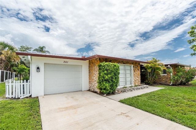 261 Caddy Rd, Rotonda West, FL 33947 - view of front of property with stone siding, concrete driveway, and an attached garage