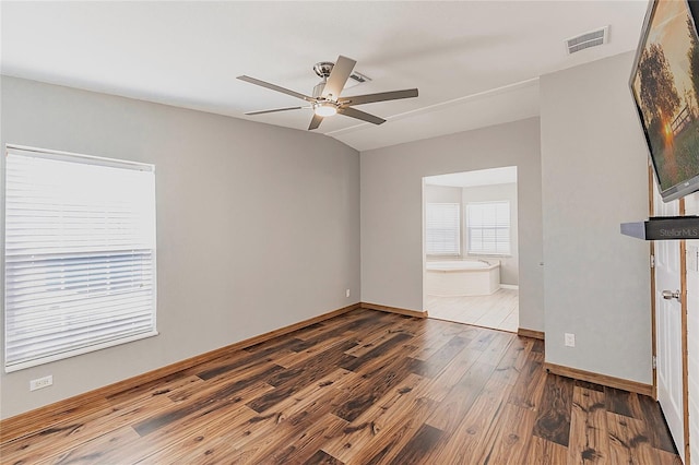 unfurnished room with a ceiling fan, baseboards, visible vents, and wood finished floors