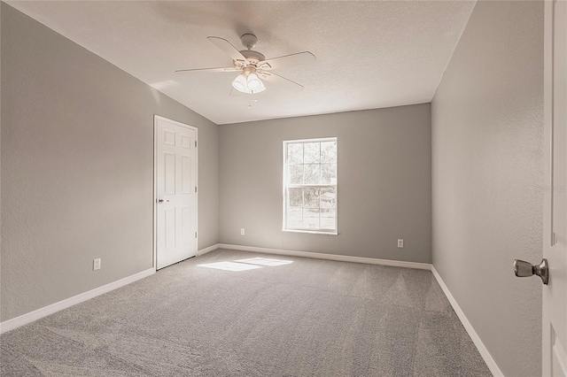 carpeted empty room with baseboards and a ceiling fan