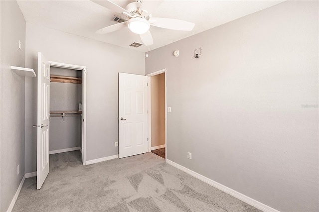 unfurnished bedroom featuring a closet, carpet flooring, baseboards, and ceiling fan