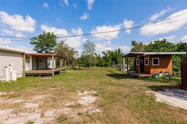 view of yard with a deck and an outdoor structure
