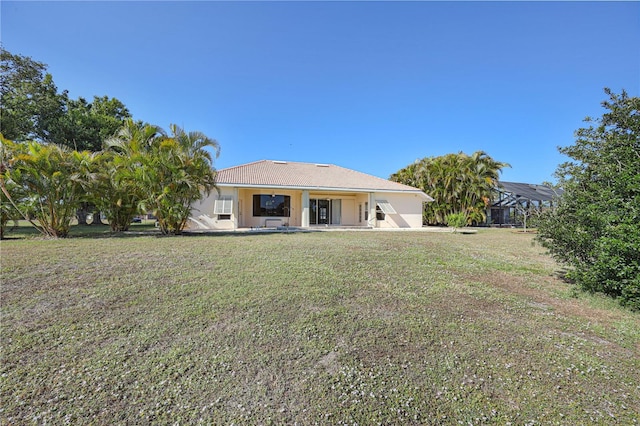 rear view of house with a lawn and a patio