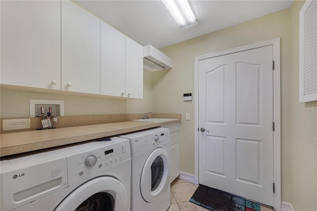 clothes washing area with washing machine and dryer, cabinet space, a sink, baseboards, and light tile patterned flooring