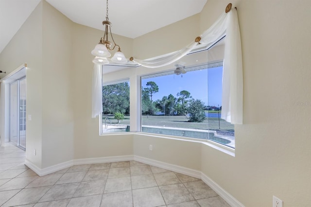 unfurnished dining area featuring baseboards, a notable chandelier, and light tile patterned floors