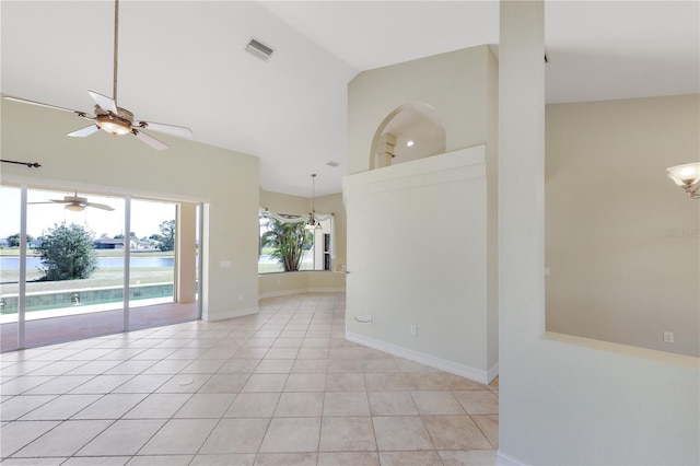 spare room with baseboards, high vaulted ceiling, light tile patterned floors, and ceiling fan with notable chandelier