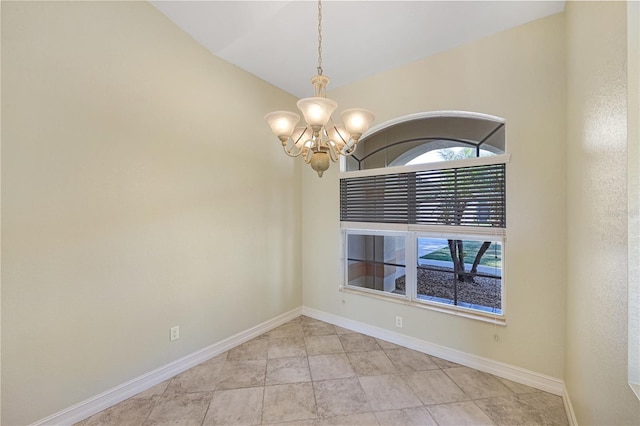 empty room featuring baseboards and a notable chandelier