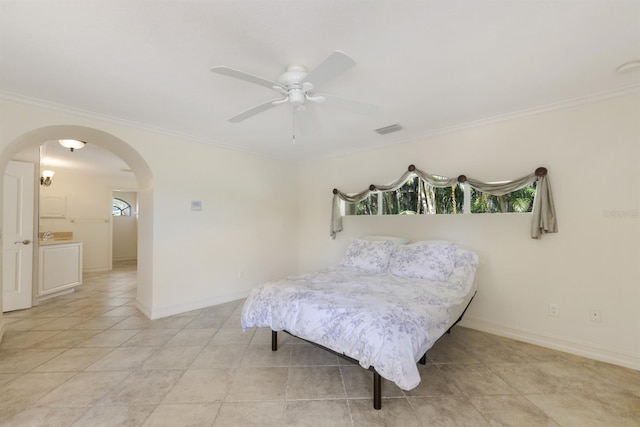 bedroom featuring crown molding, arched walkways, a ceiling fan, baseboards, and visible vents