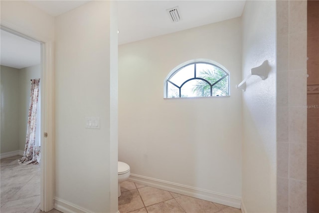 bathroom featuring toilet, baseboards, visible vents, and tile patterned flooring