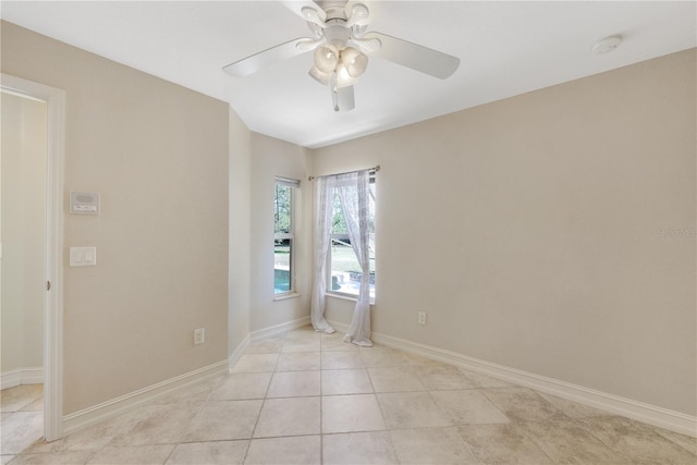 spare room featuring baseboards, a ceiling fan, and light tile patterned flooring