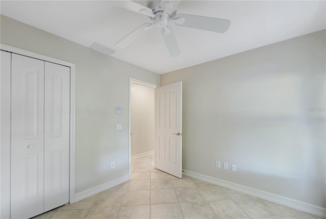 unfurnished bedroom featuring baseboards, ceiling fan, light tile patterned flooring, and a closet
