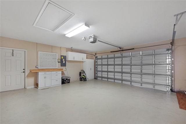 garage with a garage door opener and electric panel