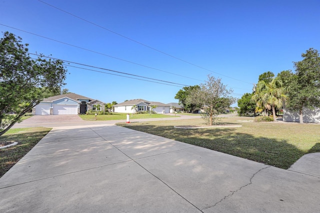 view of yard featuring concrete driveway and a residential view