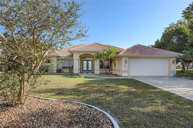 view of front of property with driveway, french doors, a tile roof, a garage, and stucco siding
