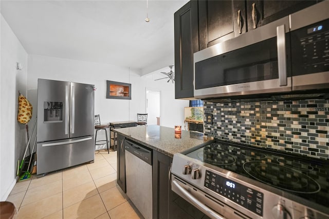 2321 Dallas St, Port Charlotte, FL 33952 - kitchen featuring decorative backsplash, ceiling fan, appliances with stainless steel finishes, light tile patterned floors, and stone countertops