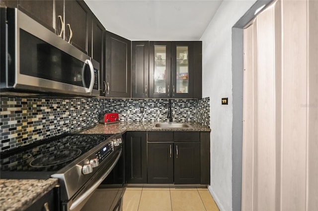 2321 Dallas St, Port Charlotte, FL 33952 - kitchen featuring light tile patterned flooring, a sink, stainless steel appliances, backsplash, and glass insert cabinets