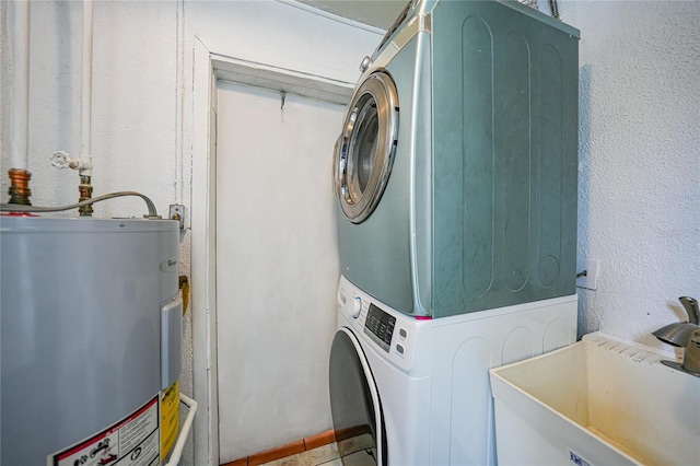 2321 Dallas St, Port Charlotte, FL 33952 - clothes washing area featuring laundry area, stacked washer / dryer, a sink, a textured wall, and electric water heater