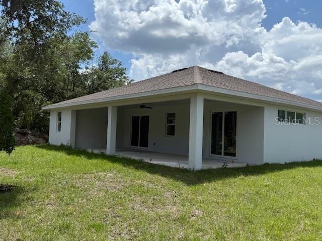 384 Prineville St, Port Charlotte, FL 33954 - rear view of property featuring stucco siding, a patio, a yard, and ceiling fan