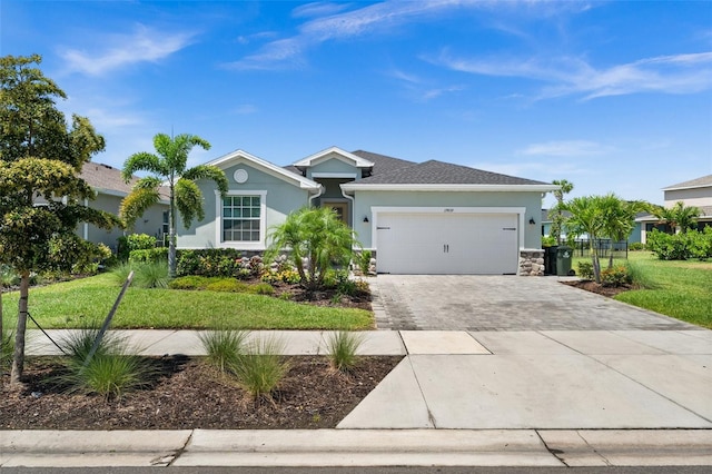 ranch-style house featuring stucco siding, an attached garage, decorative driveway, and stone siding