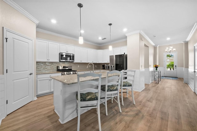 kitchen with light wood-style flooring, a chandelier, white cabinetry, and stainless steel appliances