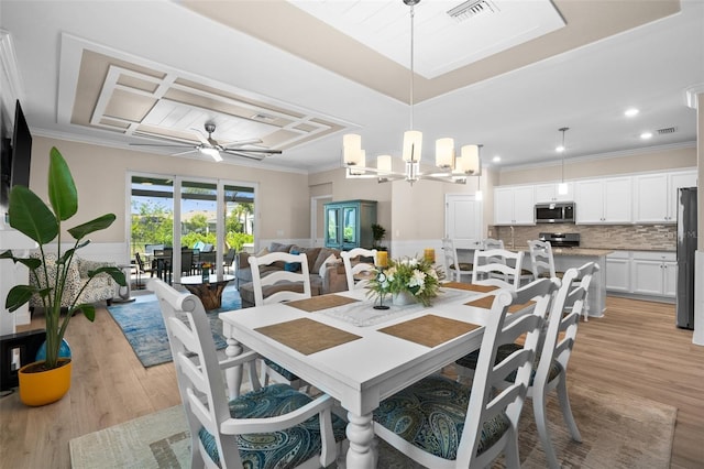 dining space with visible vents, ornamental molding, and light wood finished floors