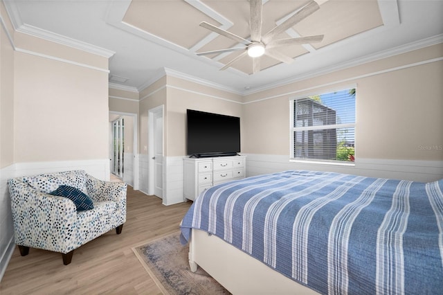 bedroom featuring crown molding, wainscoting, attic access, a ceiling fan, and light wood finished floors