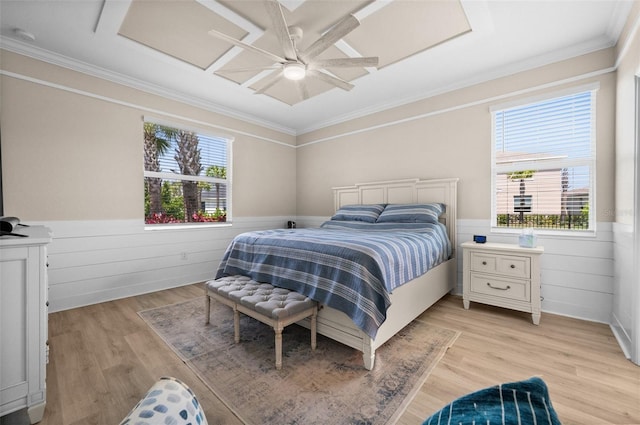 bedroom with crown molding, a wainscoted wall, and multiple windows