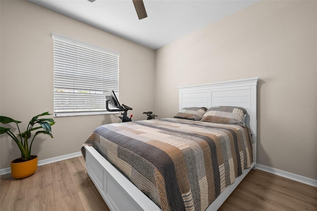 bedroom featuring baseboards, ceiling fan, and wood finished floors