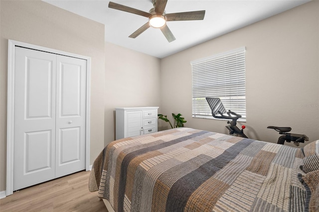 bedroom featuring a ceiling fan, light wood-style flooring, and a closet