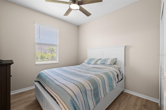 bedroom featuring baseboards, a ceiling fan, and wood finished floors