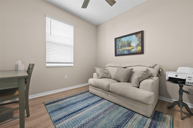 interior space with baseboards, a ceiling fan, and wood finished floors