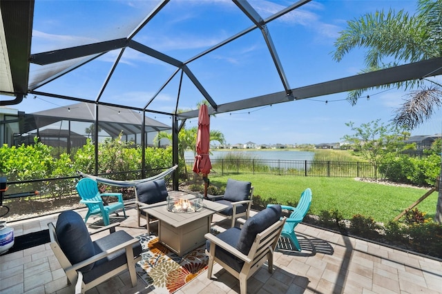 view of patio / terrace featuring fence, an outdoor living space with a fire pit, a lanai, and a water view