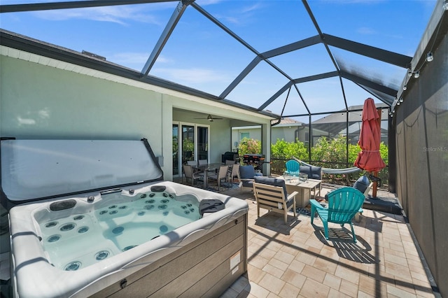 view of patio / terrace featuring a ceiling fan, a hot tub, and a lanai