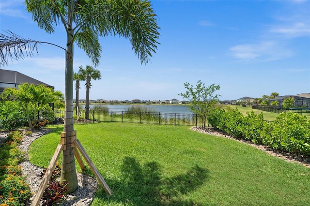 view of yard with a water view and fence