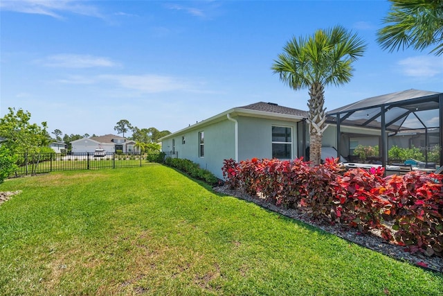 view of yard featuring fence and a lanai
