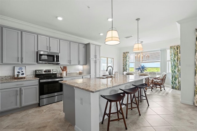14061 Heritage Landing Blvd Unit 445, Punta Gorda, FL 33955 - kitchen with visible vents, a breakfast bar area, gray cabinets, a sink, and stainless steel appliances