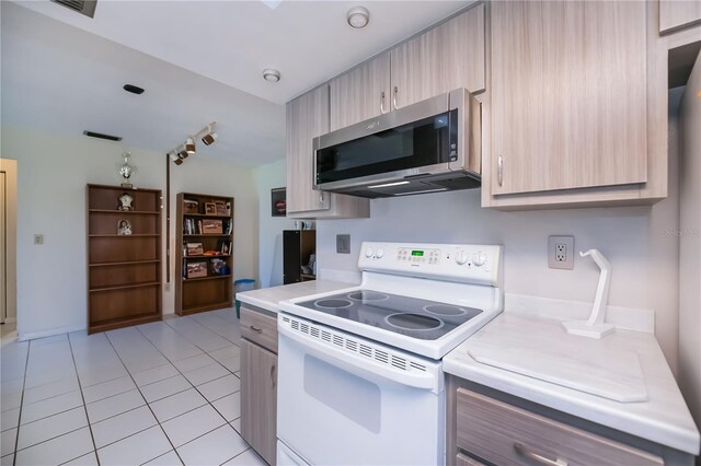 2113 Barksdale St, Port Charlotte, FL 33948 - kitchen with white range with electric stovetop, stainless steel microwave, light countertops, light tile patterned floors, and light brown cabinetry