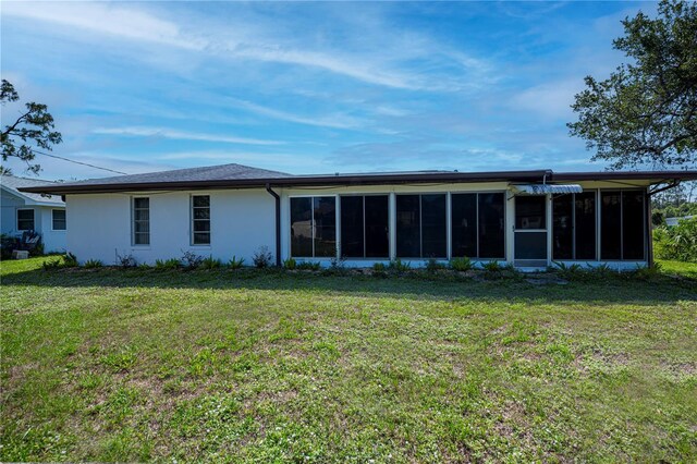 2113 Barksdale St, Port Charlotte, FL 33948 - rear view of house featuring a sunroom, stucco siding, and a yard