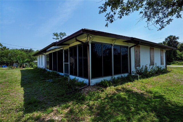 2113 Barksdale St, Port Charlotte, FL 33948 - view of side of property featuring a sunroom and a yard